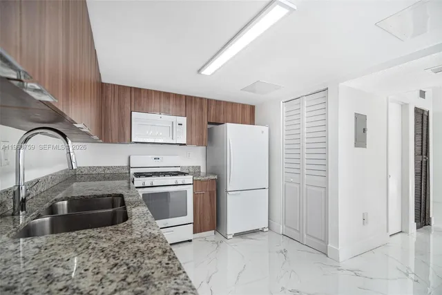 a kitchen with stainless steel appliances granite countertop a refrigerator and a stove top oven