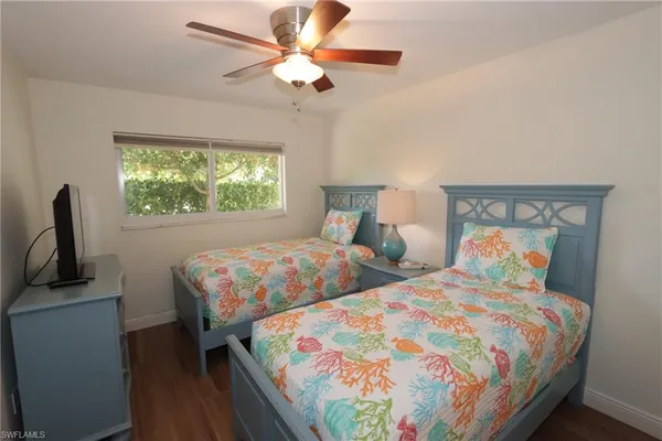 a bedroom with two beds and a flat screen tv