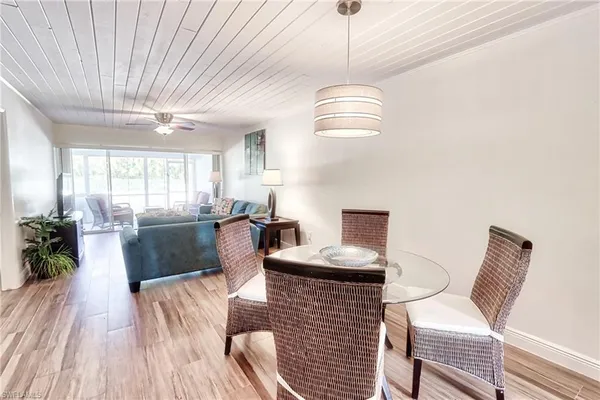 a living room with furniture a chandelier and a dining table