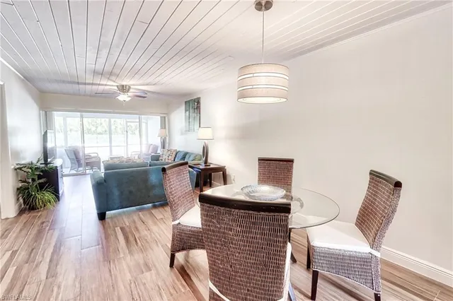 a living room with furniture a chandelier and a dining table