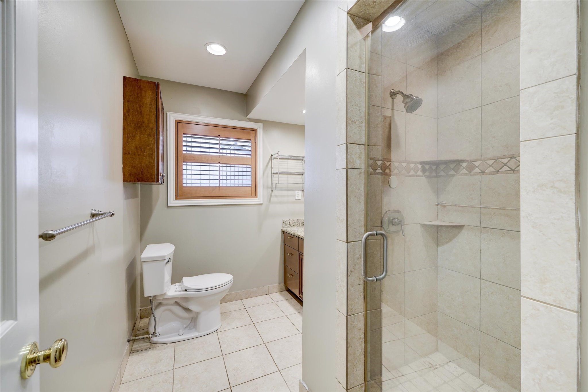 2401 Maconda Lane Houston, TX 77027 - Photo 11 of 20 An updated MASTER BATH - with tile flooring, tile walk-in shower with glass front/tile accents, recessed lighting, shuttered window, built-in linen closet.