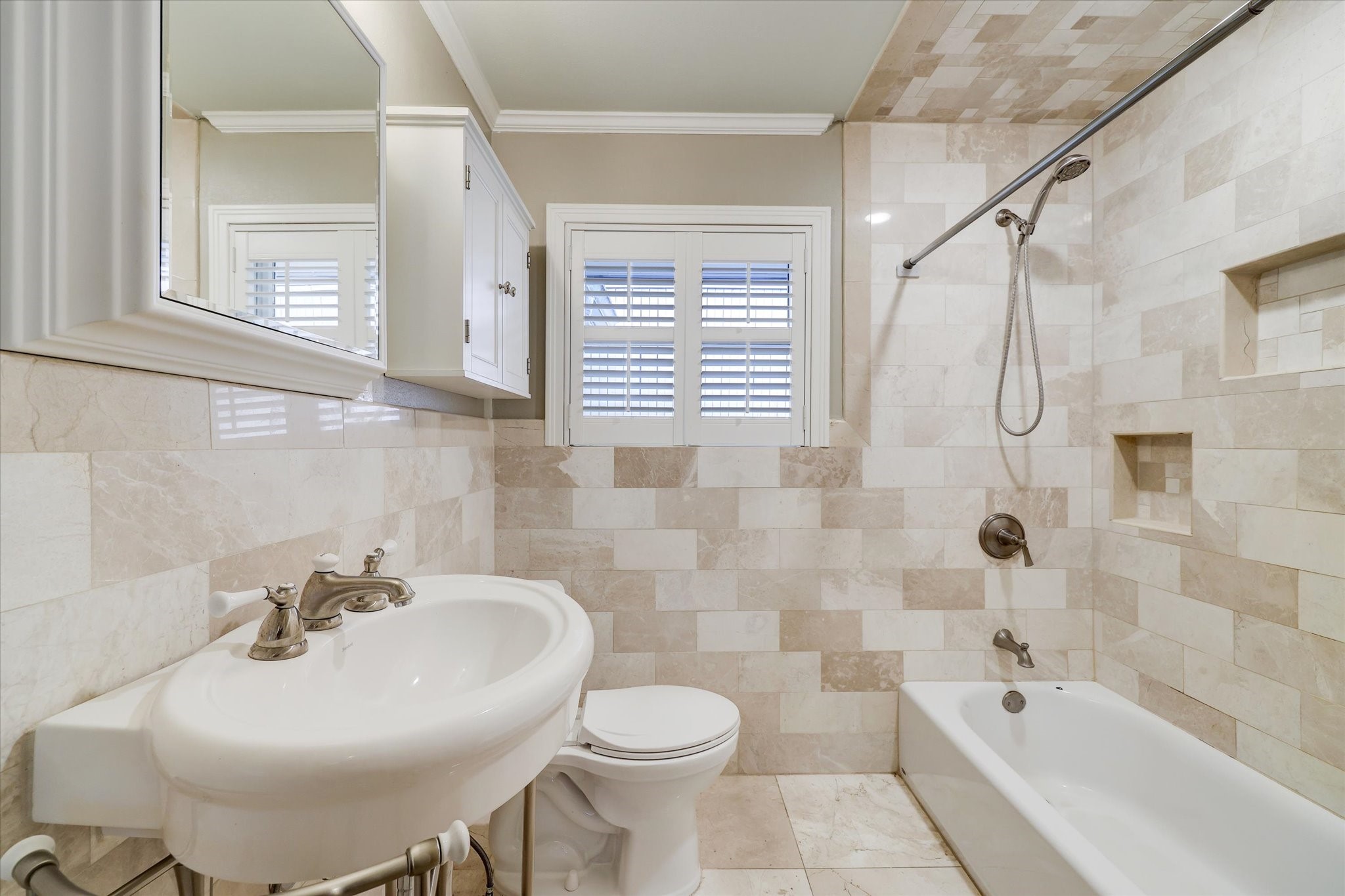 2401 Maconda Lane Houston, TX 77027 - Photo 15 of 20 Secondary BATH - subway tile surround, tub/shower with shower wand, built-in cabinets, pedestal sink, shuttered window.