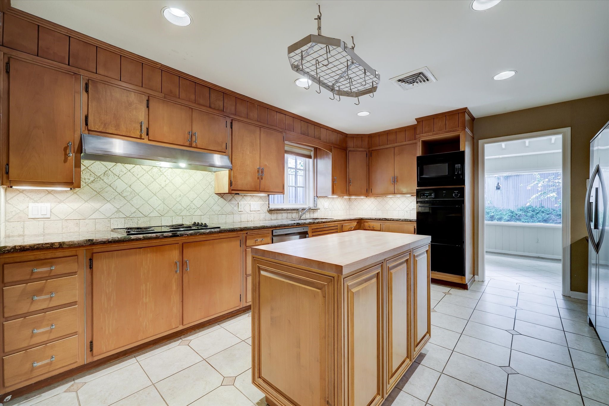 2401 Maconda Lane Houston, TX 77027 - Photo 6 of 20 Another view showing the plenitude of storage and counter space. And great appliances - Maytag dual ovens, stainless Kitchen Aid microwave, Dacor five burner stainless gas range with vent hood, LG stainless dishwasher, Samsung stainless refrigerator, dual stainless sink. All provided with great light afforded by the kitchen window, recessed lighting and under-cabinet lighting.