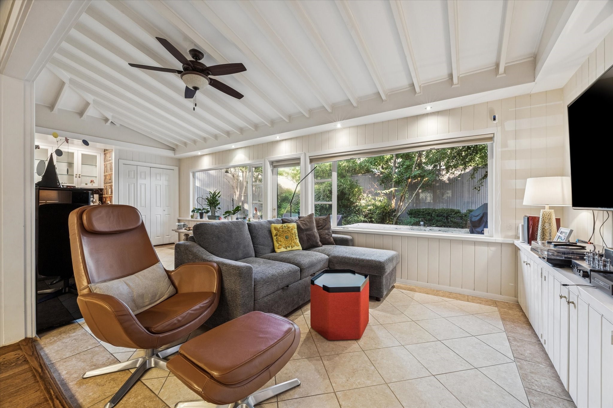 2401 Maconda Lane Houston, TX 77027 - Photo 8 of 20 A cozy DEN/SUNROOM (24 X 10) fully equipped with Wet Bar, stone tile flooring, expansive windows overlooking the backyard, ceiling fan, built-in painted cabinets, ceiling fan.