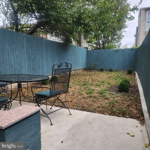 a backyard of a house with table and chairs