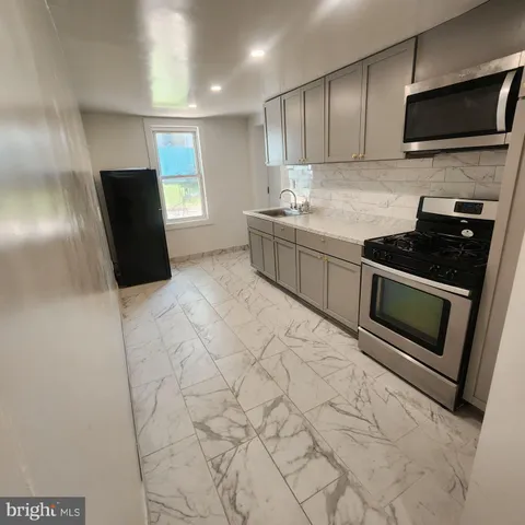 a kitchen with stainless steel appliances granite countertop a sink stove and microwave