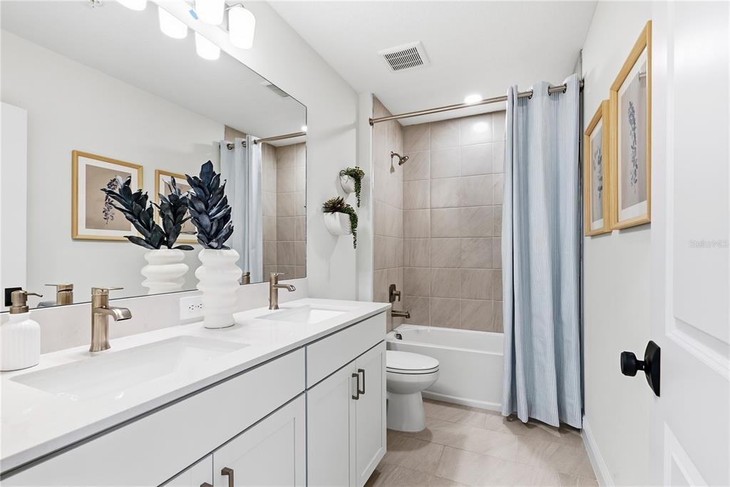 17966 Broadleaf Loop Venice, FL 34293 - Photo 12 of 19 a bathroom with a double vanity sink toilet mirror and shower