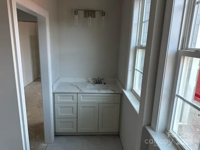 a bathroom with a granite countertop sink and a mirror