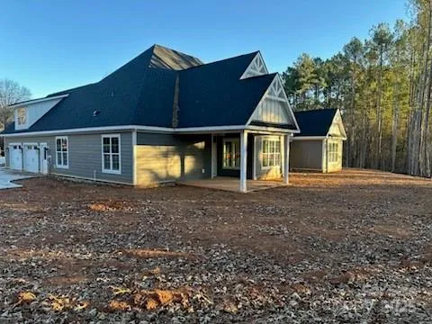 a front view of a house with large trees