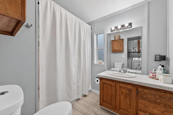 a bathroom with a sink a toilet and shower curtain