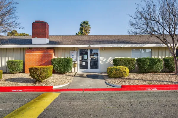 a front view of a house with a garden and trees