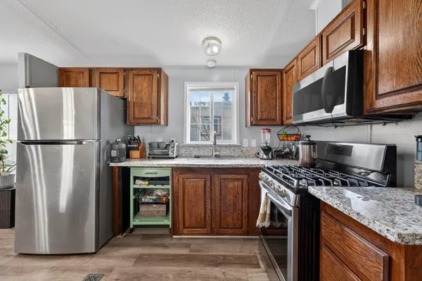 a kitchen with stainless steel appliances granite countertop a refrigerator stove and sink