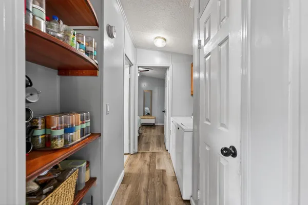a view of a hallway with closet and wooden floor