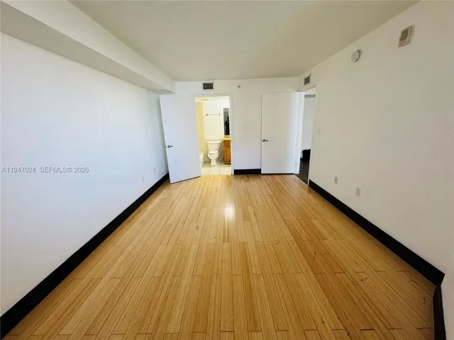 a view of a room with wooden floor