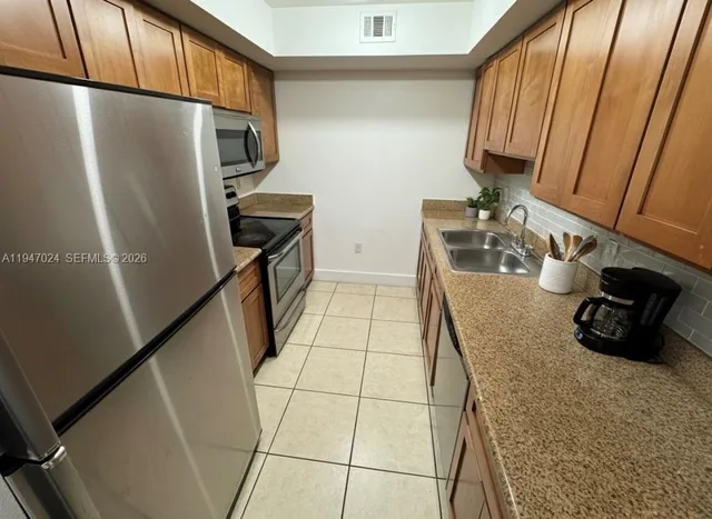 a kitchen with stainless steel appliances a refrigerator and a sink
