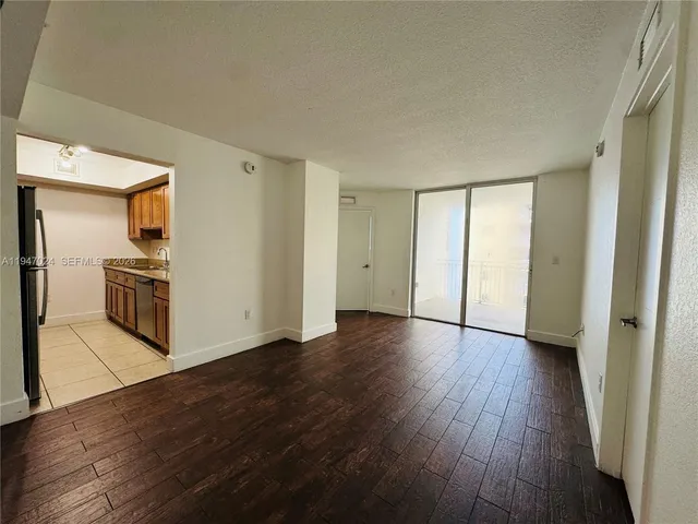 a view of a kitchen with wooden floor and a refrigerator