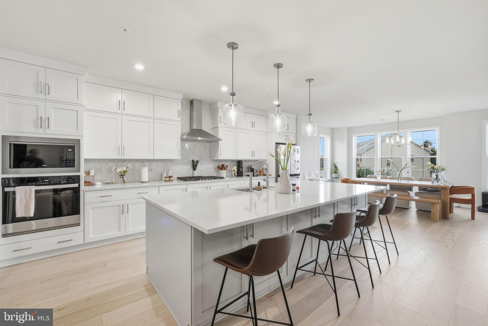 a large white kitchen with lots of counter space and furniture