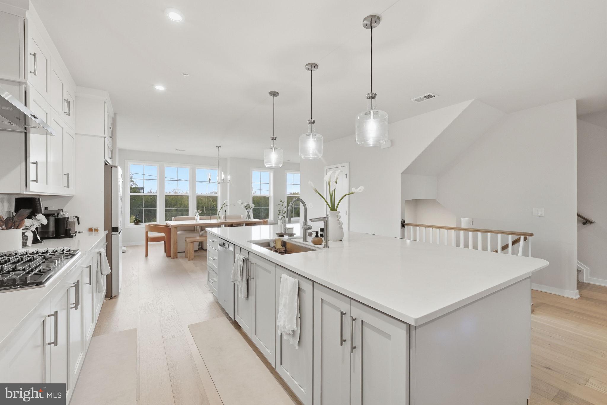 43489 Old Ryan Road Ashburn, VA 20148 - Photo 6 of 30 a kitchen with sink stove and white cabinets with wooden floor