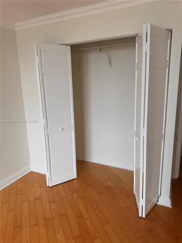 an empty room with wooden floor and entrance