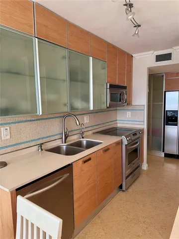 a kitchen with stainless steel appliances a sink stove and microwave