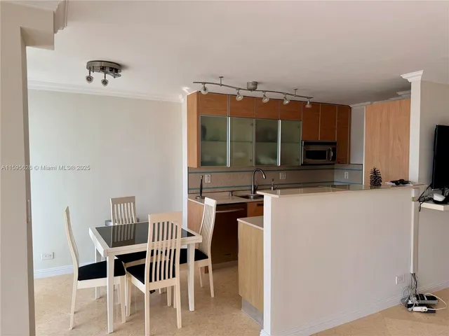 a kitchen with a dining table chairs and a refrigerator