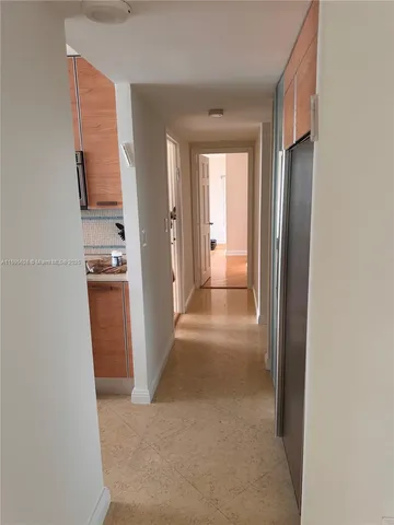 a view of a hallway with an entryway and livingroom