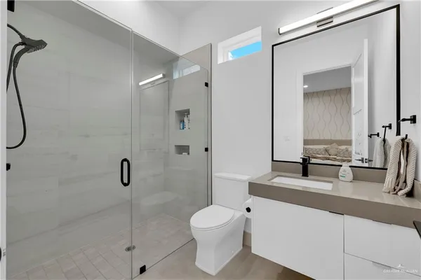 a bathroom with a granite countertop sink a toilet and a mirror