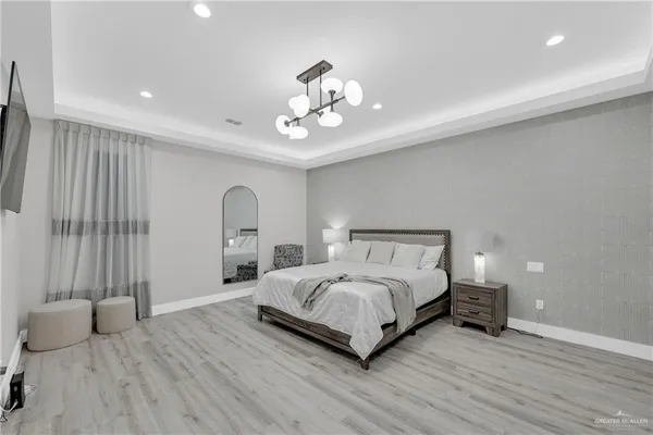 a spacious bedroom with a bed and a chandelier