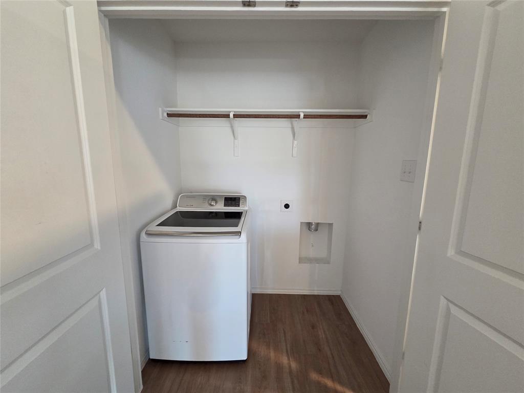 1001 Mountain Laurel Road Princeton, TX 75407 - Photo 17 of 19 Dedicated laundry closet featuring a wood-finish flooring, built-in shelving, and a wall-mounted outlet