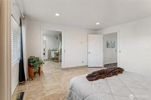 a bedroom with a bed and a potted plant