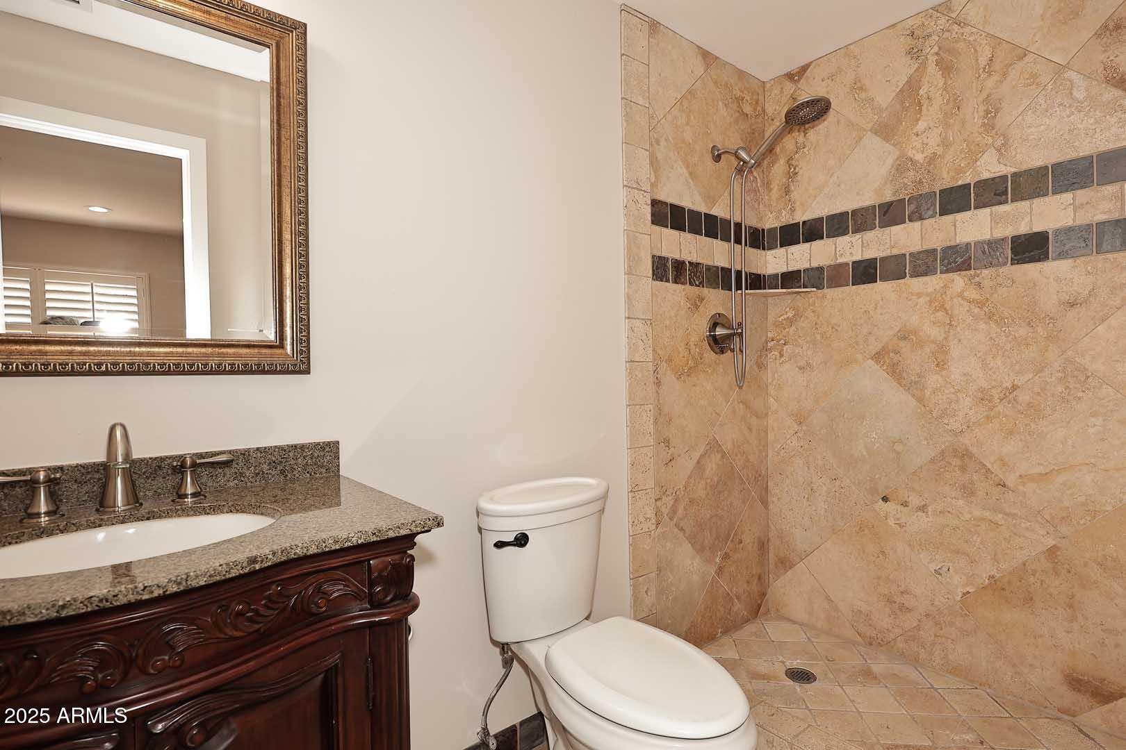 5449 East Thunderbird Road Scottsdale, AZ 85254 - Photo 24 of 75 a bathroom with a granite countertop sink toilet a shower and a mirror