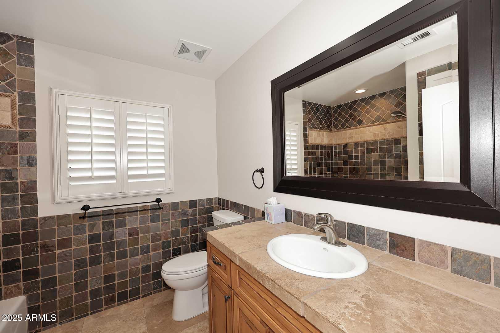 5449 East Thunderbird Road Scottsdale, AZ 85254 - Photo 29 of 75 a bathroom with a sink a toilet a mirror and window