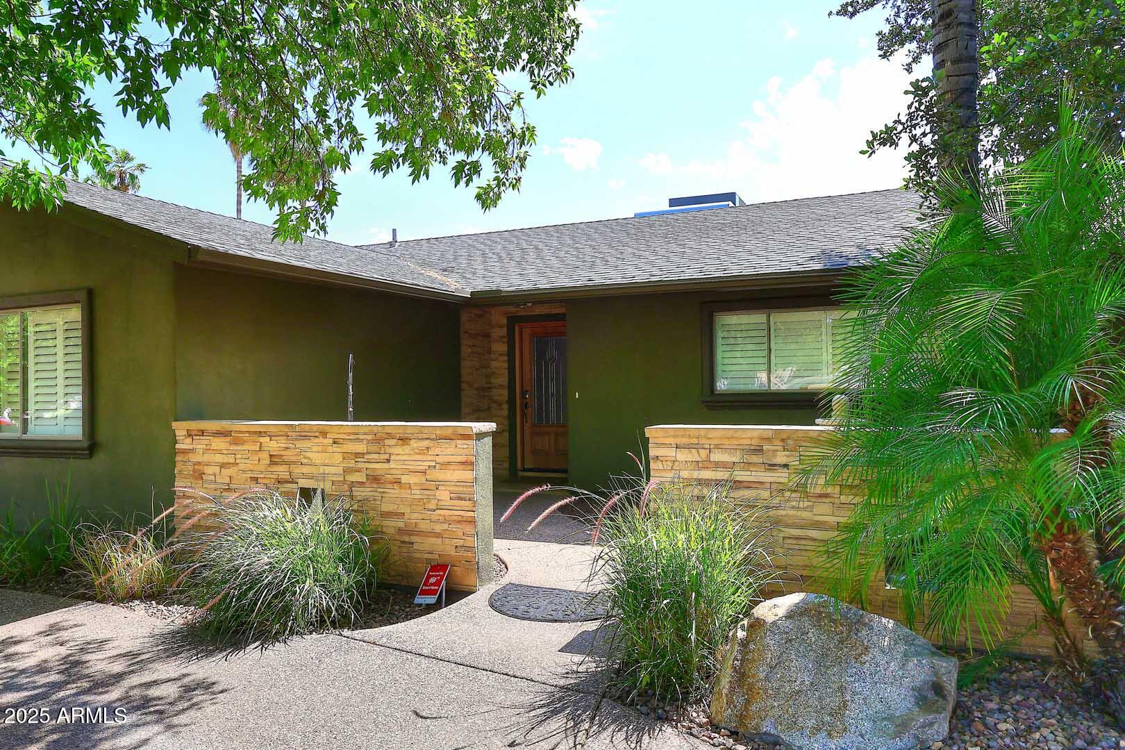 5449 East Thunderbird Road Scottsdale, AZ 85254 - Photo 9 of 75 a front view of a house with garden