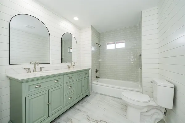 a bathroom with a double vanity sink toilet and shower