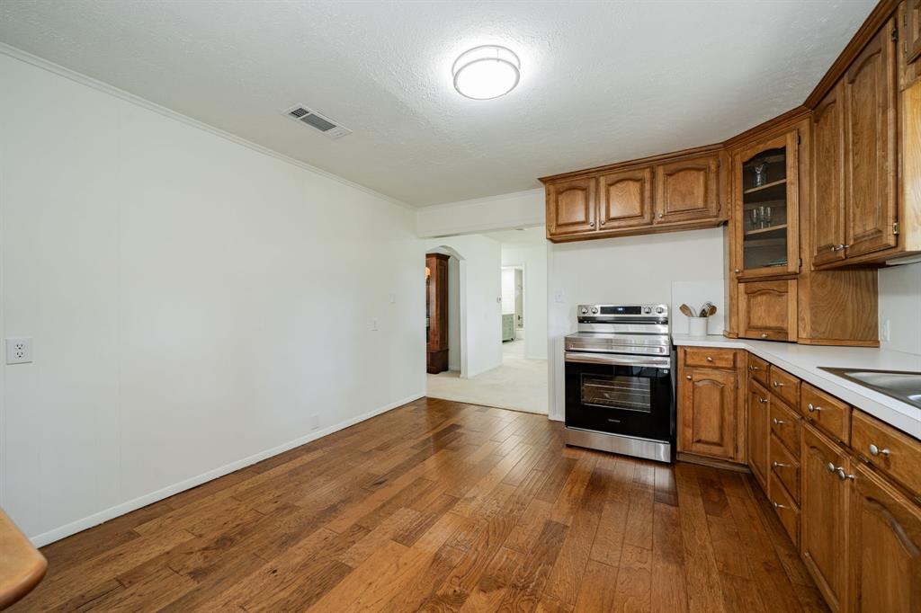 809 Cobb Street Bridgeport, TX 76426 - Photo 29 of 39 a kitchen with granite countertop a stove cabinets and wooden floor