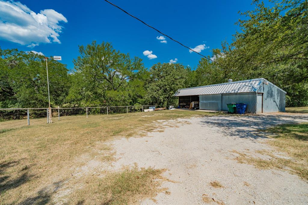 809 Cobb Street Bridgeport, TX 76426 - Photo 37 of 39 a backyard of a house with large trees and plants