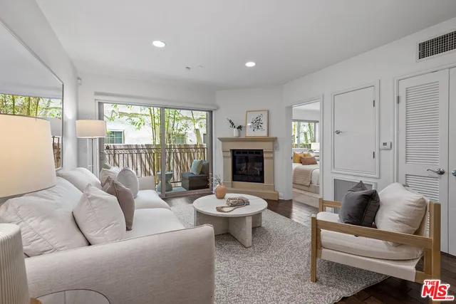 a living room with furniture a fireplace and a large window