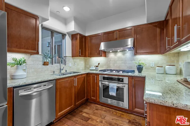 a kitchen with stainless steel appliances granite countertop a stove a sink and a microwave