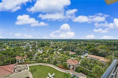 a view of a city with lawn chairs and large trees