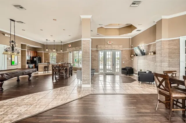 a kitchen with stainless steel appliances granite countertop a table chairs and a wooden floor