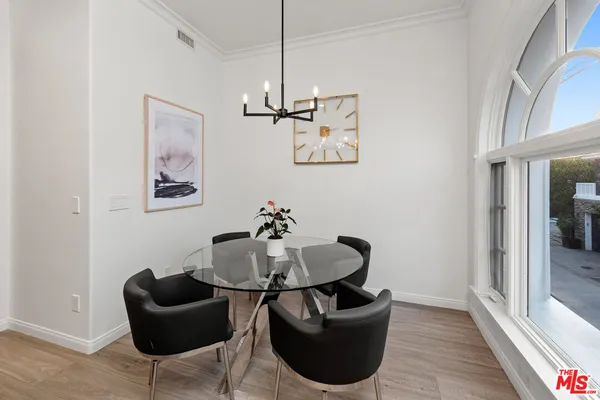 a kitchen with a stove a sink dishwasher and white cabinets with wooden floor