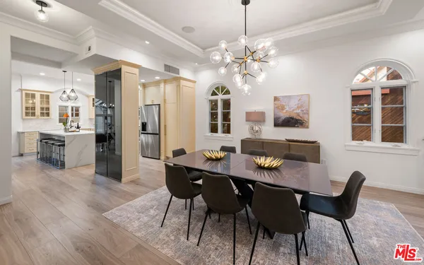 a view of a a dining room and livingroom with furniture wooden floor a chandelier