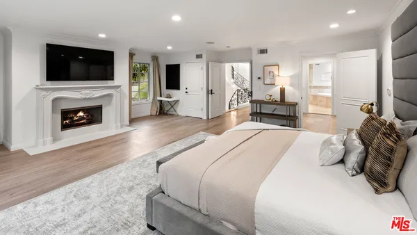 a spacious bedroom with a large bed and a flat screen tv