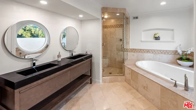 a bathroom with a white tub a mirror and a shower