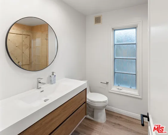 a hallway with white cabinets and wooden floor