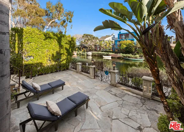 a view of swimming pool with two windows and plants