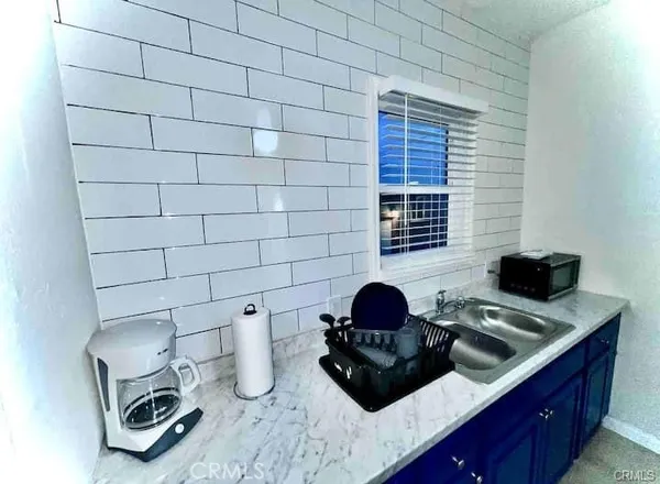 a kitchen with a sink a stove and a wooden floor