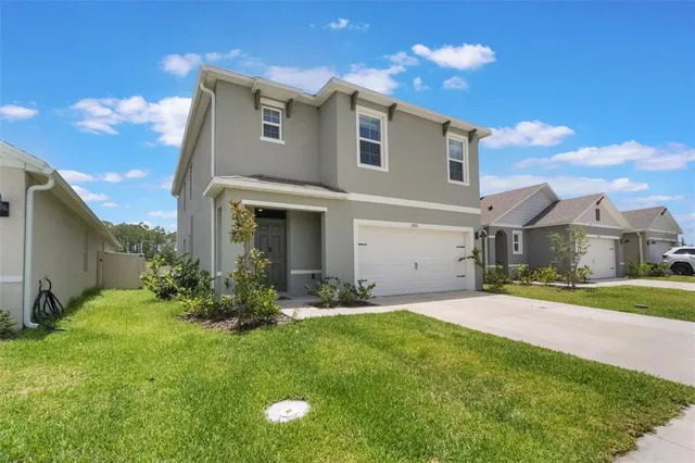 a front view of a house with a yard and garage