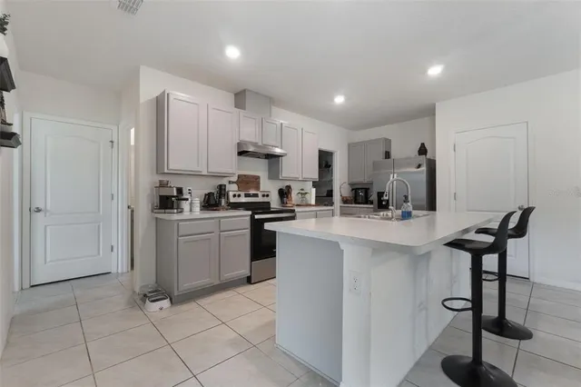 a kitchen with cabinets and chairs