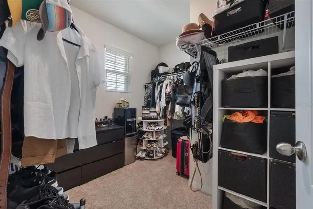 a view of walk in closet with clothes and shoes